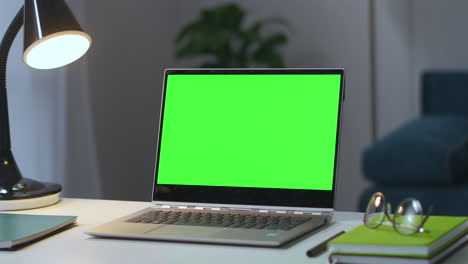 Öffnen-Sie-Ein-Notebook-Mit-Chroma-Key-Bildschirm-Auf-Dem-Arbeitstisch-Im-Leeren-Wohnzimmer-Und-Zoomen-Sie-Mit-Dem-Laptop-Zu-Hause-Auf-Das-Grüne-Display.